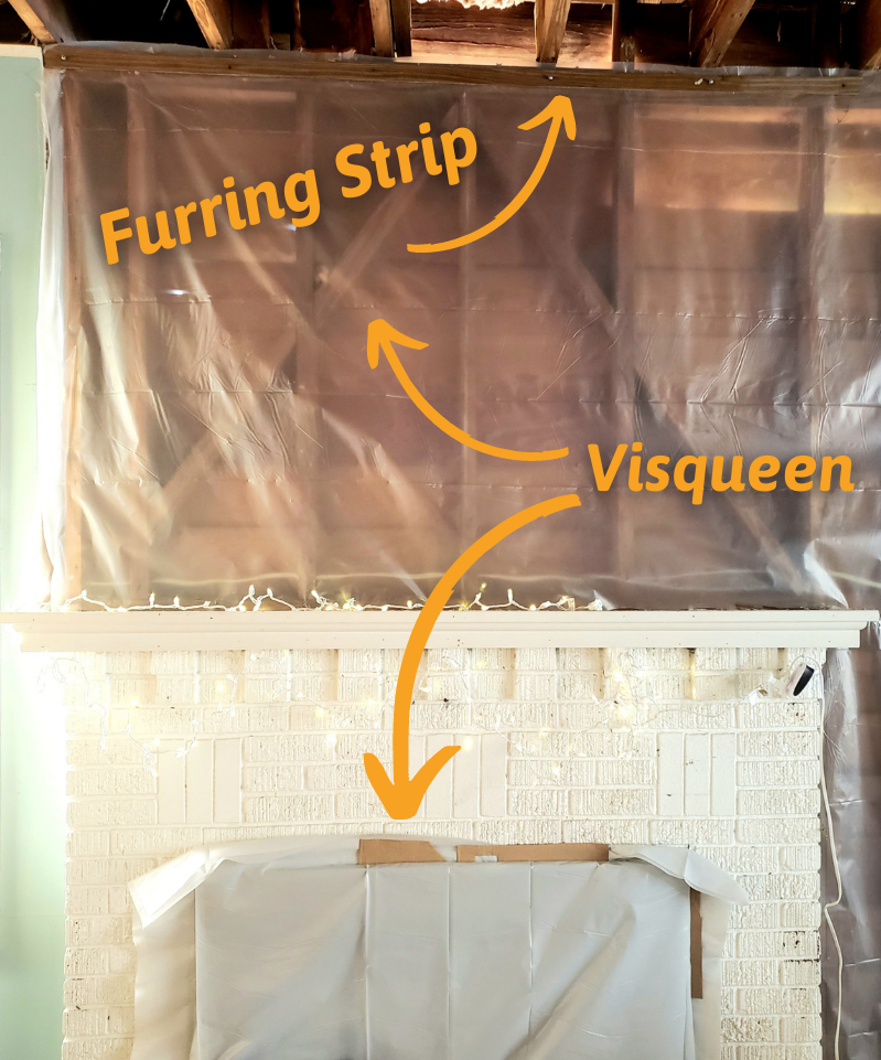 Disaster recovery solution 3.  Image of visqueen plastic installed over bare wall above white brick mantle.  Detailed with arrows pointing to visqueen and where to install a furring strip along the top.